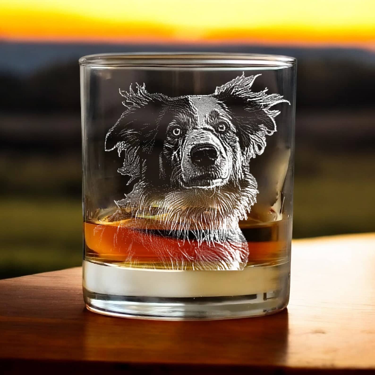 The Custom Pet Portrait Wine/Whiskey Glass from My Store, featuring an engraved border collie's face against the blurred backdrop of a sunset over a field, is the ideal Christmas gift for pet parents.