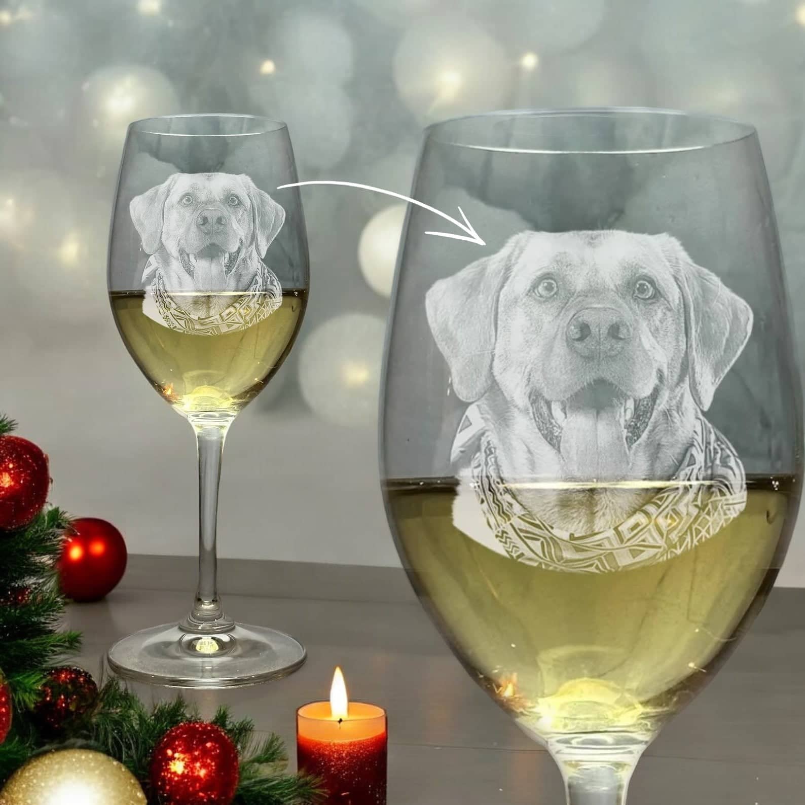 A pair of personalized wine glasses etched with a dog's image from "My Store," showcasing one in sharp focus, filled with white wine, while the dog's face is intricately detailed with a bandana. The ambiance is enhanced by a lit candle and Christmas ornaments, making it an ideal festive gift for dog moms during the holidays.